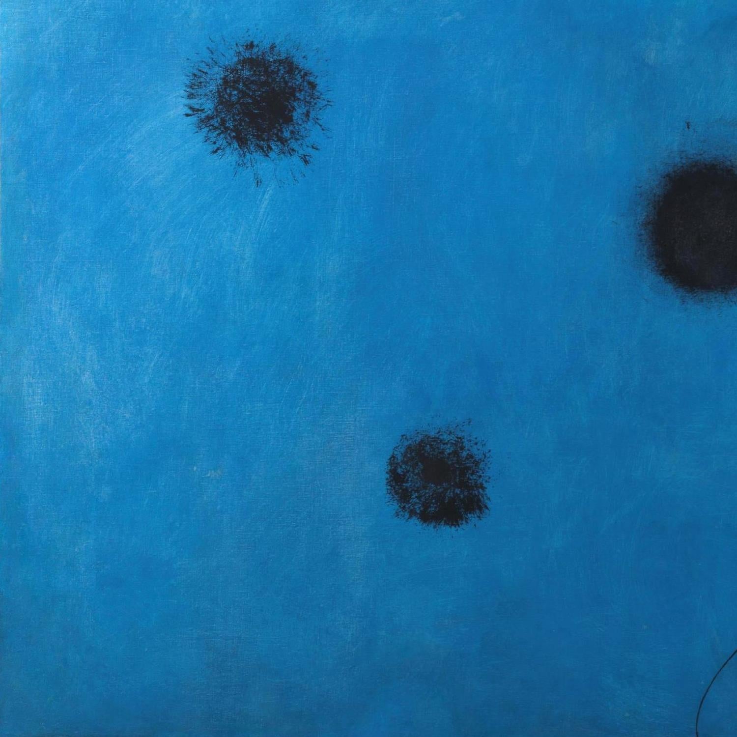 Three black circular spots on a blue textured background