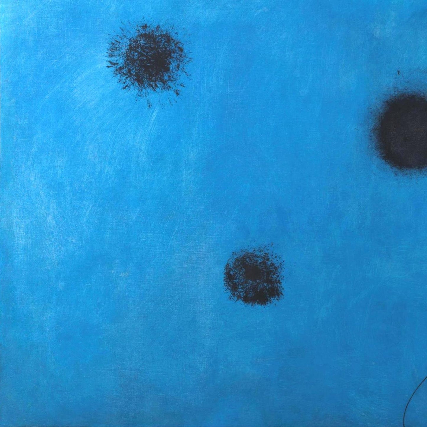 Three black spots on a blue textured background