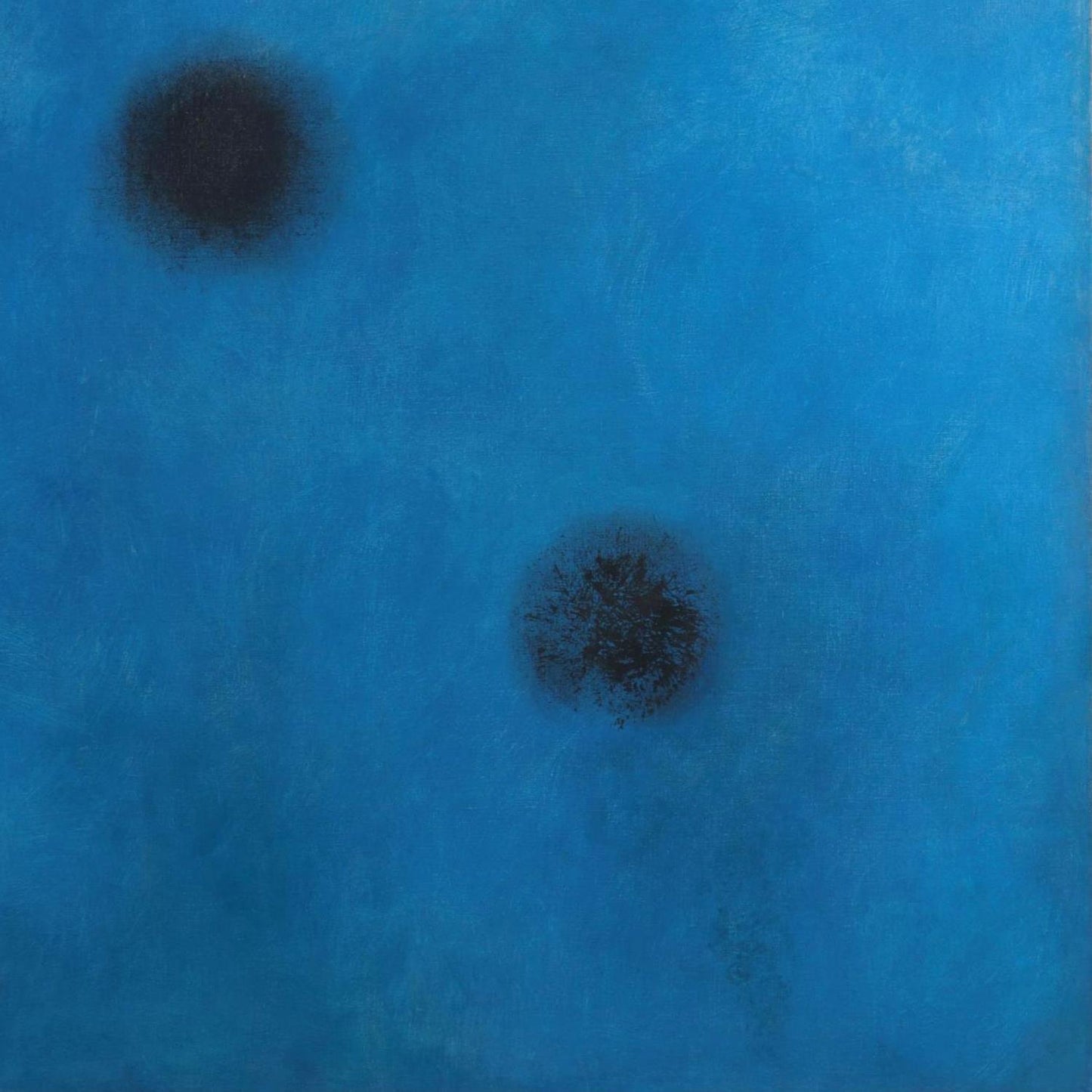 Two black spots on a blue textured background