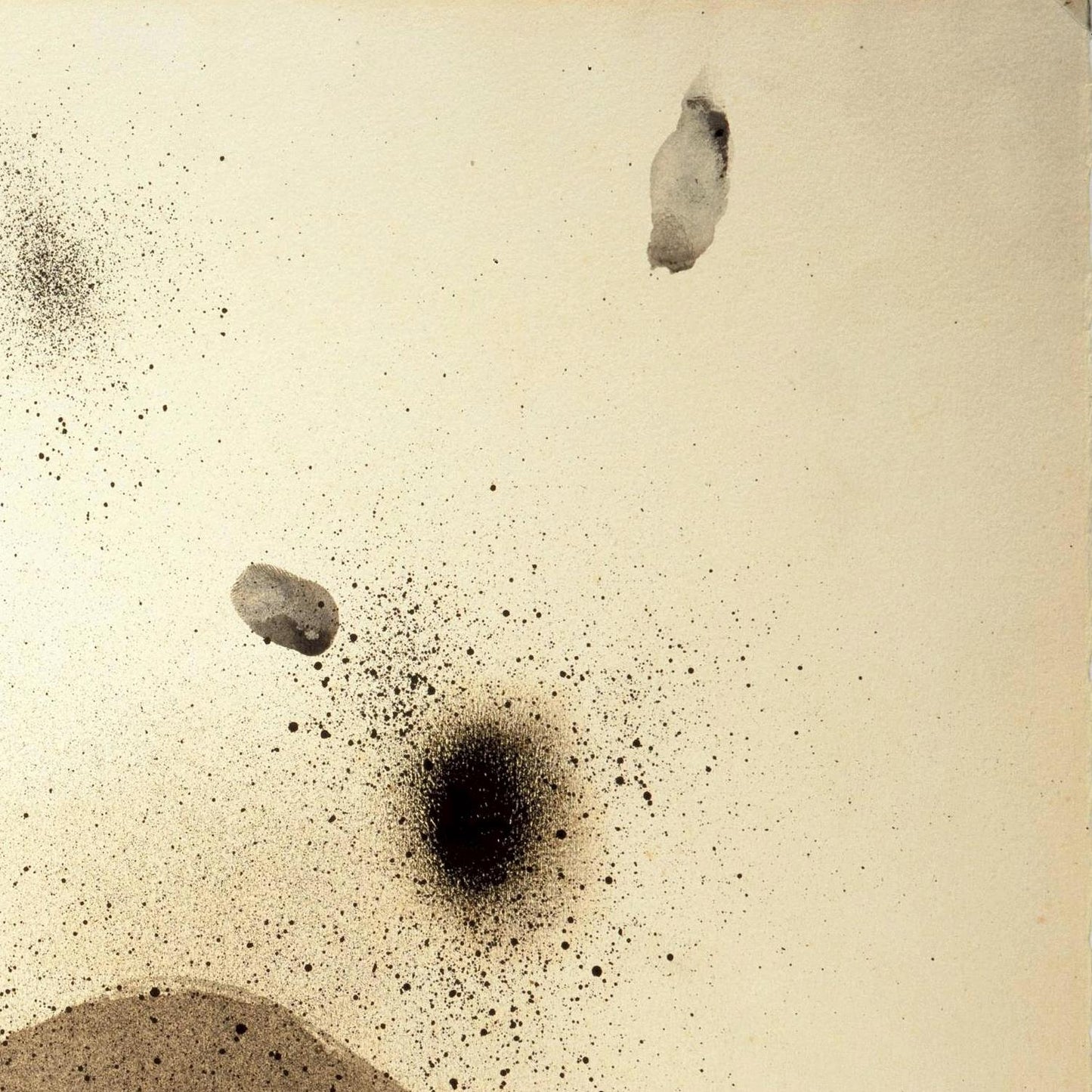 Close-up of a textured beige surface with black specks and a central dark spot.