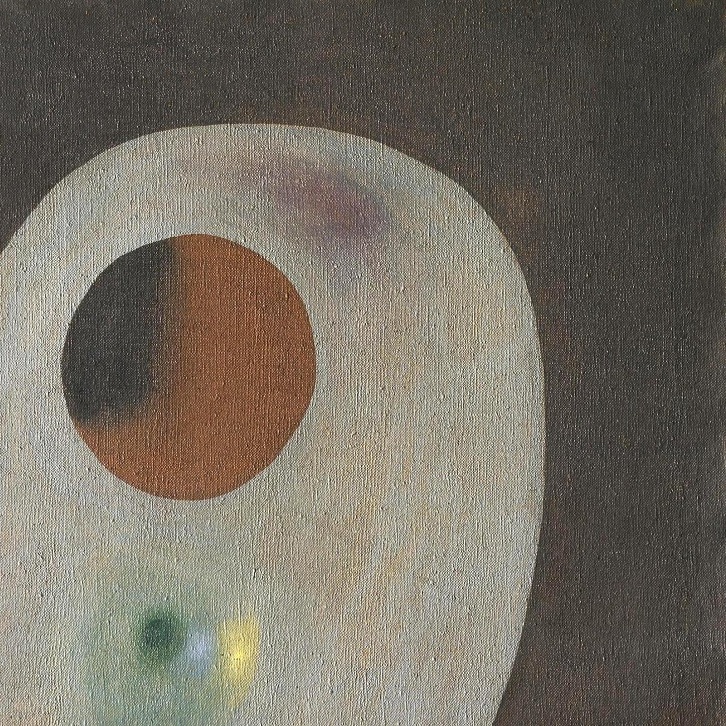 Abstract art with a large circular shape and smaller colored shapes on a dark background