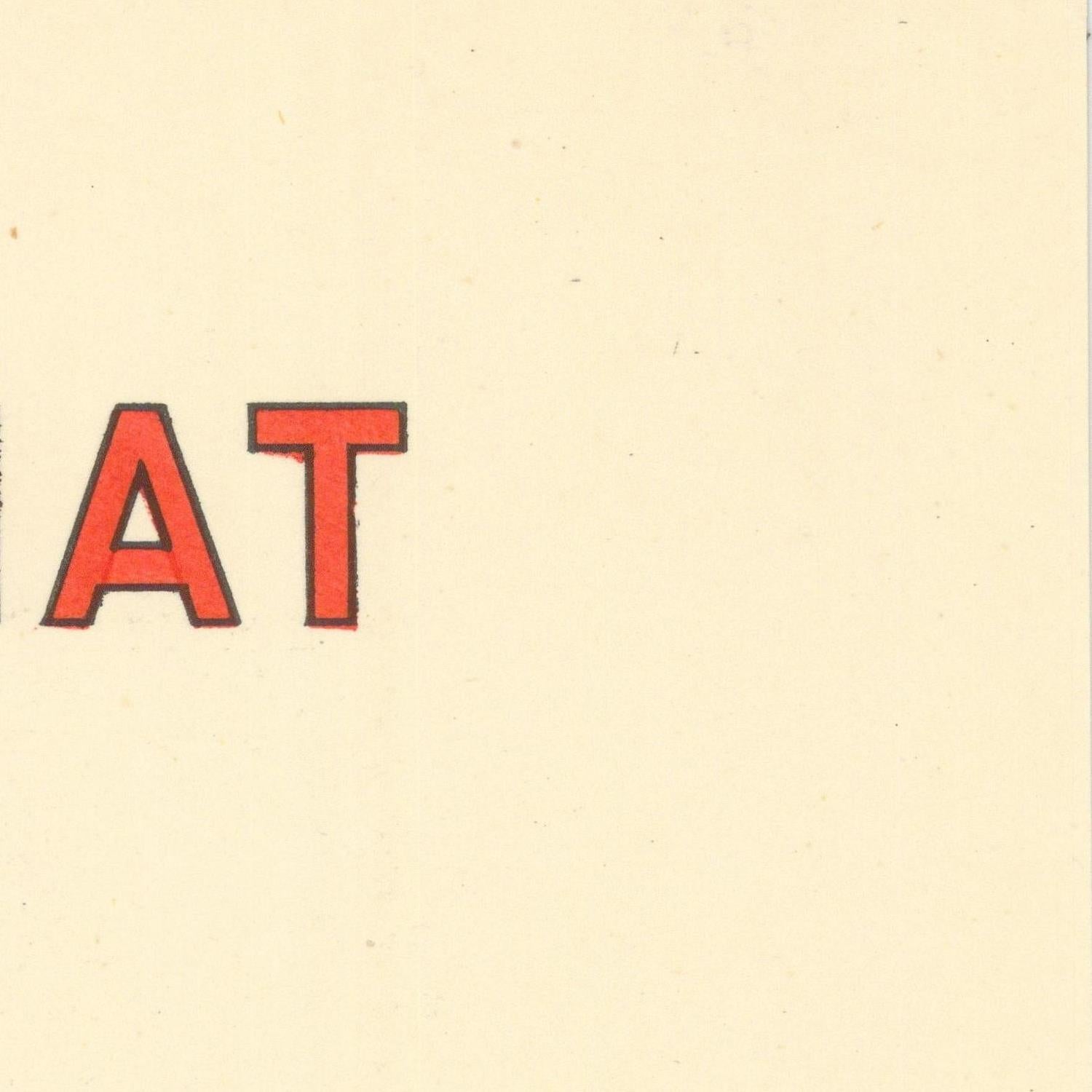 Red letters 'AT' on a beige background