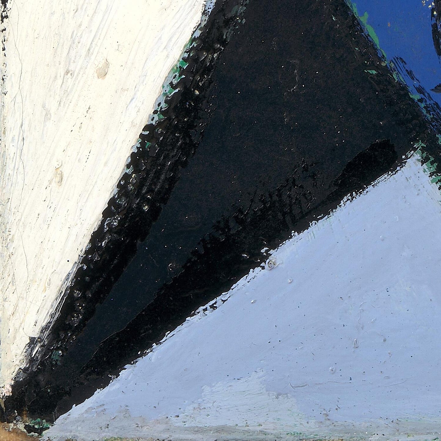 Close-up of a boat's hull with a white wall and blue water in the background